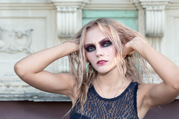 An outdoor fashion gothic style portrait of a beautiful blonde girl