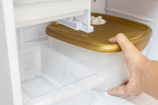 Hand holding box in refrigerator