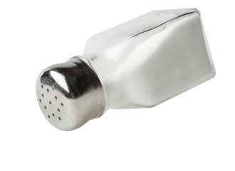 Pouring salt from a salt shaker on white background