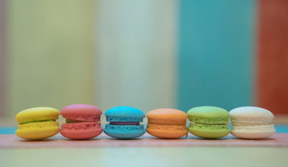 Multicolored macaroons on white wooden background. . Macaron or Macaroon is sweet meringue-based confection