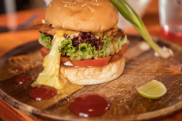 Closeup of beautifully served fresh home made burger isolated on wooden cutting board