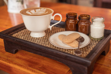 Closeup of beautifully served cup of latte coffee with butter biscuits