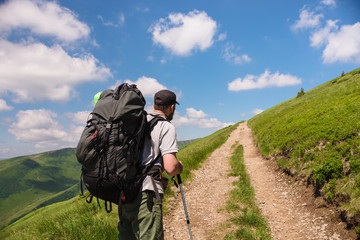 Fototapeta na wymiar traveler with backpack and trekking poles on the road
