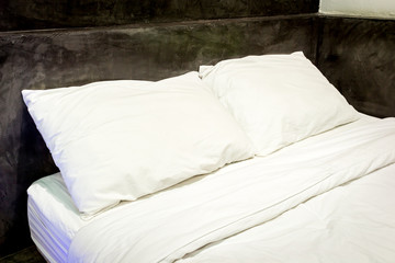White pillows on a bed and bedding sheets on the bed