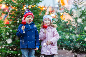 Two little kids eating sugar apple on Christmas market