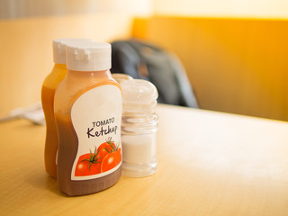focus shot of tomato ketchup in plastic bottles, salt and pepper