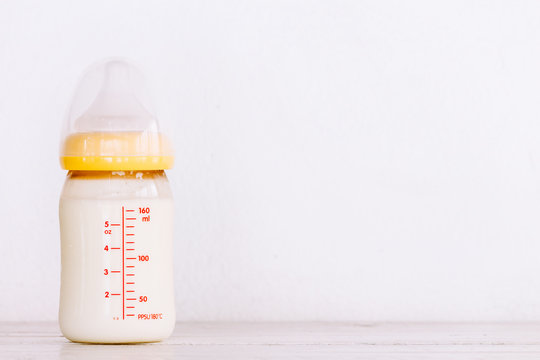 Baby bottle with milk  on wooden table