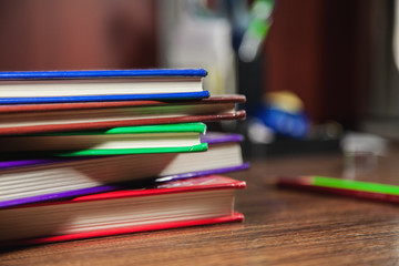 Different color books on dark wooden table