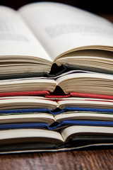 Stack of open books on wooden table