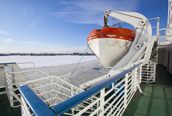 View from the Gulf of Finland covered with ice on St. Petersburg seaport and a lifeboat from a...