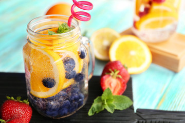 Refreshing water with fruits on table
