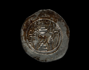 Ancient silver Sassanian coin with patina isolated on black