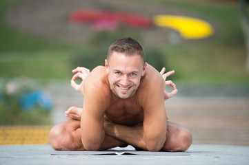 Athletic man doing yoga asanas in the park