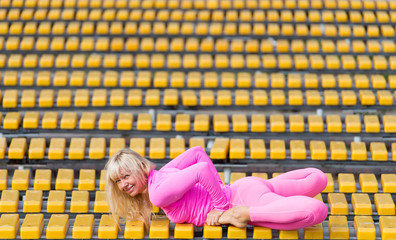 Pretty young woman doing yoga asanas in the park