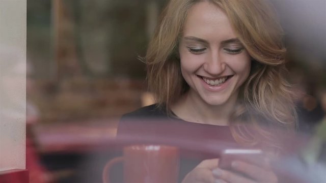 Beautiful woman using app on smartphone in cafe