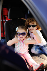 children sit in the car and play