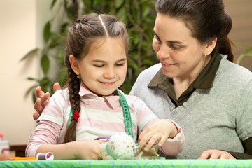 Fototapeta premium Little girl and mother sewing