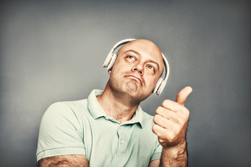 man listening to music on headphones, shows ok