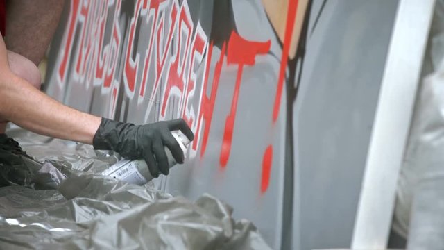 Street Artist Painting A Graffiti On The Wall