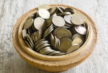 Old bowl filled with Thai baht coin