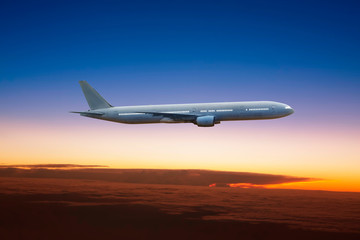 Fototapeta na wymiar Airplane flying high above the clouds at sunset .