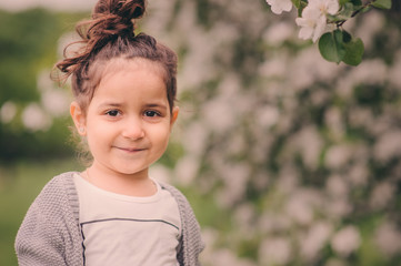 cute dreamy toddler child girl walking in blooming spring garden, celebrating easter outdoor