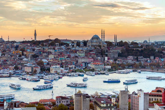 Tourist boat sails on the Golden Horn in Istanbul at sunset, Turkey.