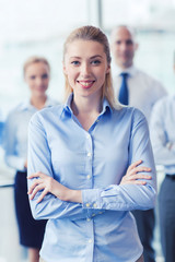 smiling businesswoman with colleagues in office