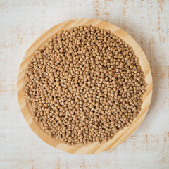 Raw giant wholegrain couscous in wooden bowl