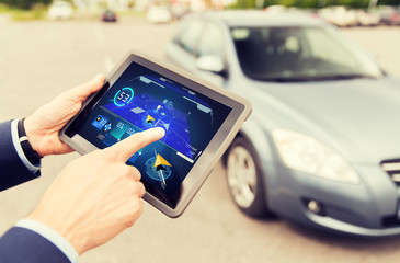 male hands with navigator on tablet pc and car