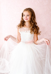 Adorable smiling little girl in white princess dress