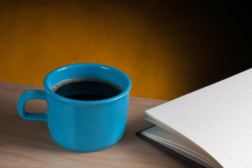 cup of coffee and opened notebook paper