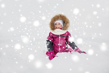 happy little kid or girl in winter clothes on snow