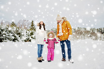 happy family with child in winter clothes outdoors