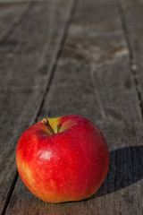 Einzelner reifer Apfel auf einem Holztisch