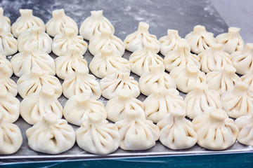 National Georgian cuisine Khinkali metal background Cook prepares khinkali kitchen Top view raw meat dough dish uncooked Street food booth selling Chinese specialty Steamed Dumplings Process cooking