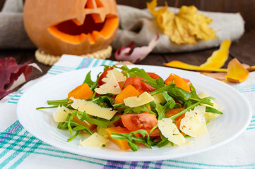 Dietary salad with pumpkin, fresh tomatoes, arugula and Parmesan.