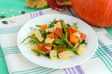 Dietary salad with pumpkin, fresh tomatoes, arugula and Parmesan.