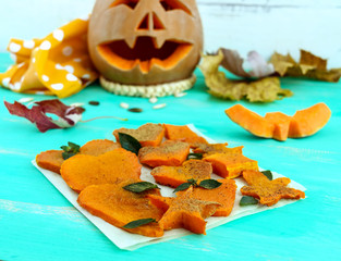 Honey Baked slices of pumpkin in the form of various figures, decorating mint leaves. Lovely snacks for a party (Halloween). Children's menu.