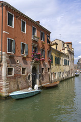 Fototapeta na wymiar Canal and boats in Venice, a famous city in northeastern Italy and the capital of the Veneto region