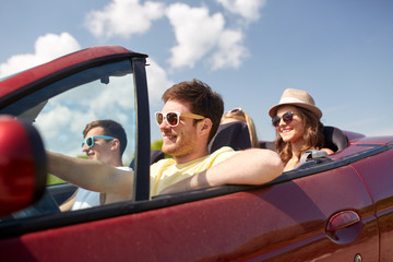 happy friends driving in cabriolet car