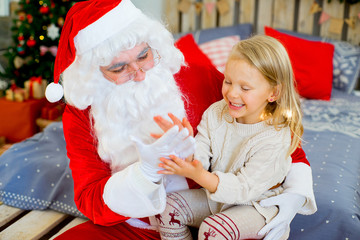 Santa Claus and cute girl getting ready for Christmas