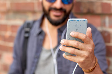 man with earphones and smartphone on street