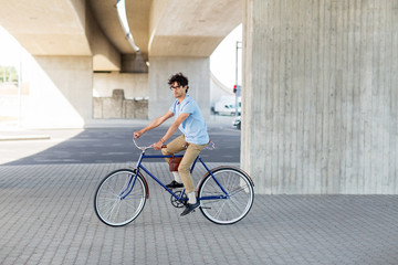 young hipster man riding fixed gear bike