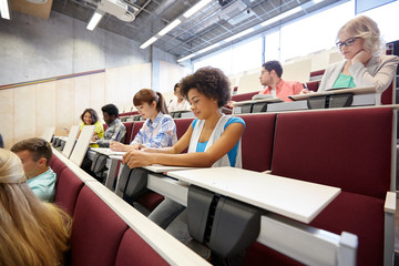 group of students with notebooks at lecture hall