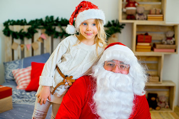 Santa Claus and cute girl getting ready for Christmas