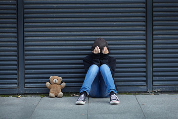 young homeless boy sleeping on the street