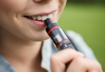 Young girl vaping e-cig device