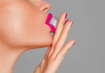 Close-up shot of woman's lips with ice cube

