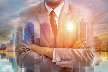 Double exposure of businessman and blurred city in sunrise.